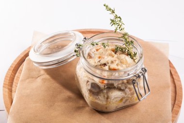 Beyaz arka plan üzerinde ahşap bir tabakta tencerede rosto