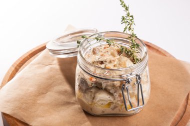 Beyaz arka plan üzerinde ahşap bir tabakta tencerede rosto