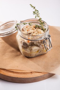 Beyaz arka plan üzerinde ahşap bir tabakta tencerede rosto