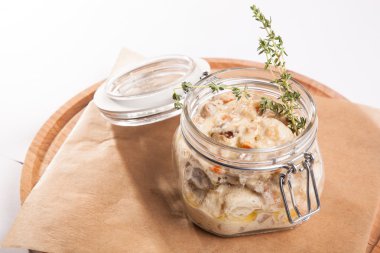 Beyaz arka plan üzerinde ahşap bir tabakta tencerede rosto