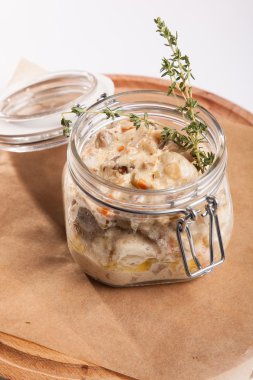 Beyaz arka plan üzerinde ahşap bir tabakta tencerede rosto