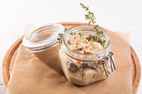 Beyaz arka plan üzerinde ahşap bir tabakta tencerede rosto