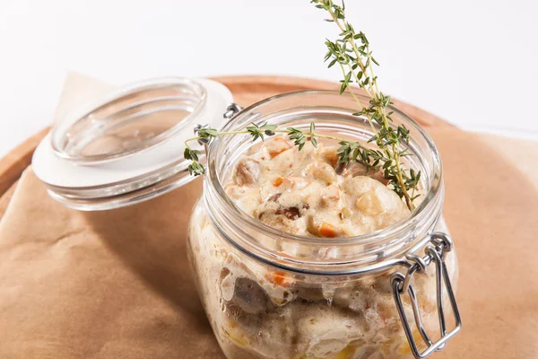 Beyaz arka plan üzerinde ahşap bir tabakta tencerede rosto