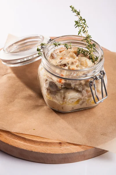 Beyaz arka plan üzerinde ahşap bir tabakta tencerede rosto