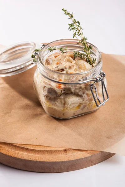 Beyaz arka plan üzerinde ahşap bir tabakta tencerede rosto