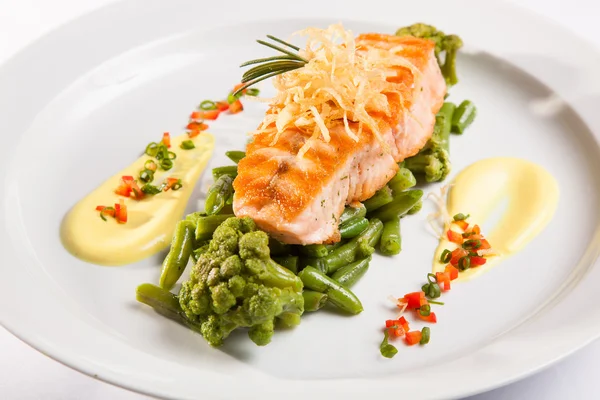 Beyaz tabakta yeşil fasulyeli somon bifteği