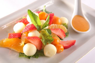 Tabakta tatlı soslu meyve ve meyve salatası.