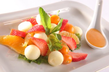 Tabakta tatlı soslu meyve ve meyve salatası.