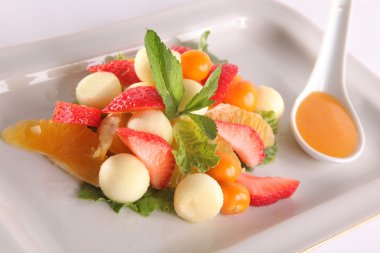 Tabakta tatlı soslu meyve ve meyve salatası.