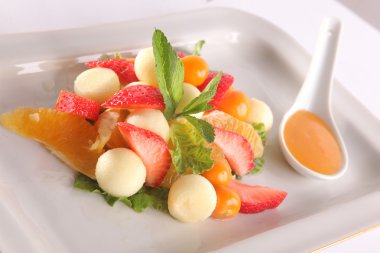 Tabakta tatlı soslu meyve ve meyve salatası.