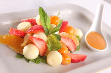 Tabakta tatlı soslu meyve ve meyve salatası.