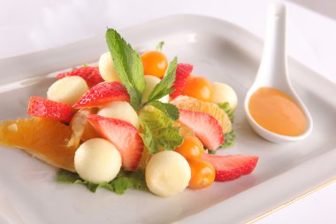 Tabakta tatlı soslu meyve ve meyve salatası.