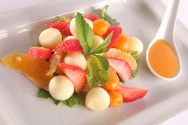 Tabakta tatlı soslu meyve ve meyve salatası.