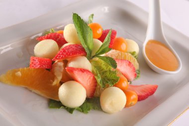 Tabakta tatlı soslu meyve ve meyve salatası.