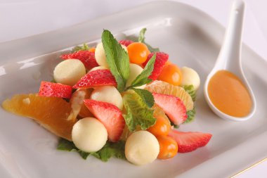 Tabakta tatlı soslu meyve ve meyve salatası.