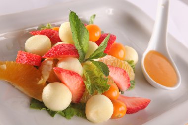 Tabakta tatlı soslu meyve ve meyve salatası.