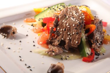 Susamlı biftek ve tabakta mantar.