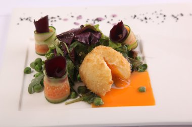 Soslu tavuk pirzolası ve tabakta garnitür.