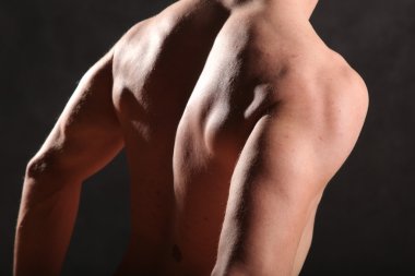 Çıplak erkek gövdesi ve siyah arka planda kas.