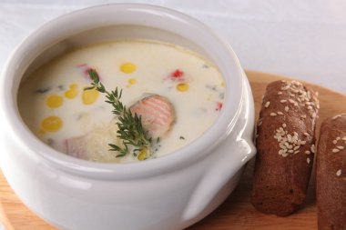 Ahşap masada füme somon ile kremalı çorba.