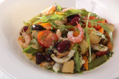 Deniz mahsullü salata ve tabakta sebze.