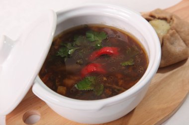 Tabaktaki tahta kesme tahtasındaki mantar çorbası.