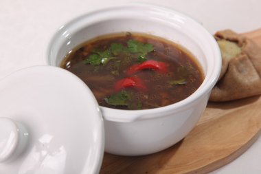 Tabaktaki tahta kesme tahtasındaki mantar çorbası.