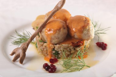 Soslu köfte ve tabakta bulgur.