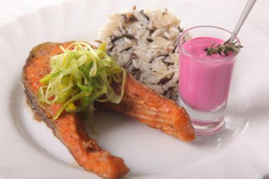 Kızarmış somon, yanında pilav ve sos.