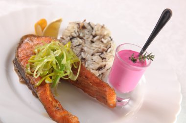 Kızarmış somon, yanında pilav ve sos.