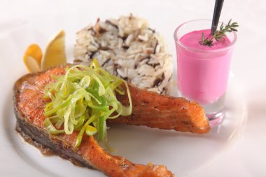 Kızarmış somon, yanında pilav ve sos.