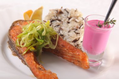 Kızarmış somon, yanında pilav ve sos.