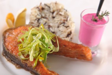 Kızarmış somon, yanında pilav ve sos.