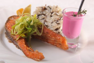 Kızarmış somon, yanında pilav ve sos.