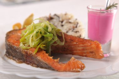 Kızarmış somon, yanında pilav ve sos.