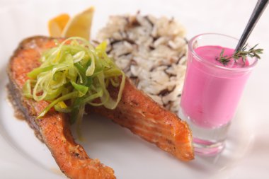 Kızarmış somon, yanında pilav ve sos.