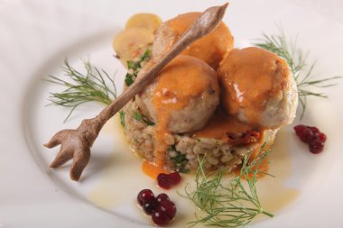 Soslu köfte ve tabakta bulgur.