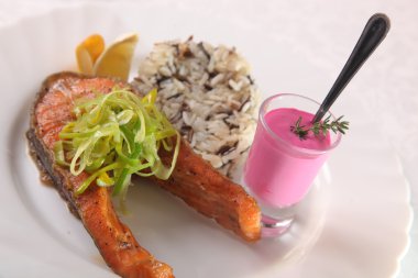 Kızarmış somon, yanında pilav ve sos.