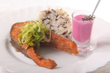 Kızarmış somon, yanında pilav ve sos.