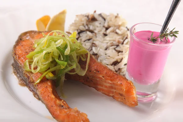 Kızarmış somon, yanında pilav ve sos.