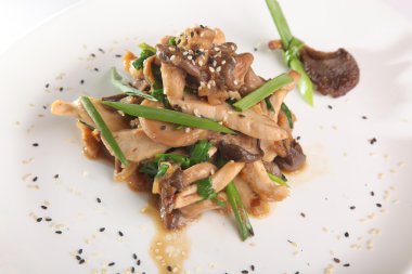 Tabağında et olan sıcak mantar salatası.