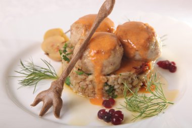 Soslu köfte ve tabakta bulgur.