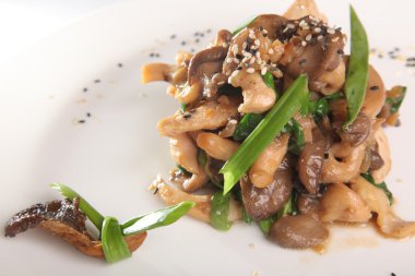 Tabağında et olan sıcak mantar salatası.