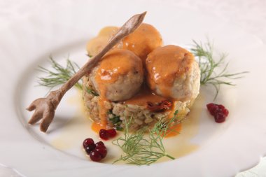 Soslu köfte ve tabakta bulgur.