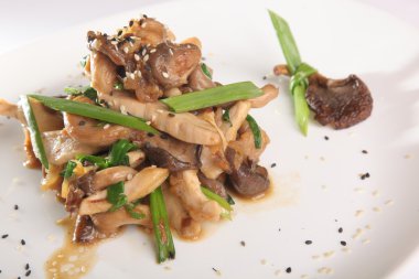 Tabağında et olan sıcak mantar salatası.