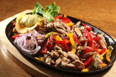 ahşap masa üzerinde tavada sığır eti fajita