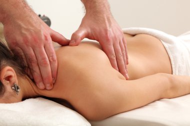 Masör spa salonunda kadın vücuduna masaj yapıyor..