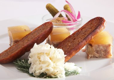 Tabağında salatalık turşusu ve kızarmış ekmek ile aspic.