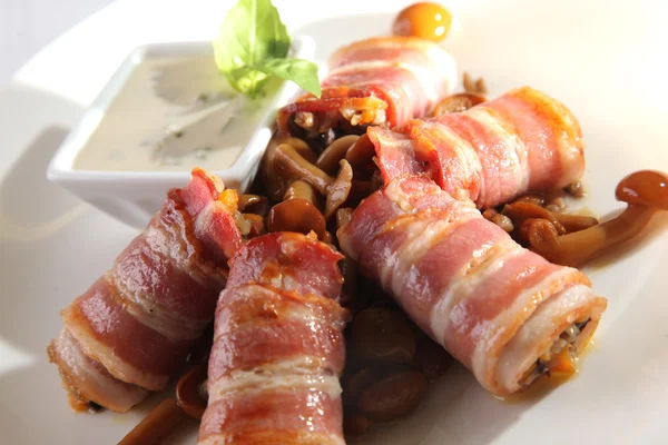 roll with Bacon and mushrooms and sauce on white plate
