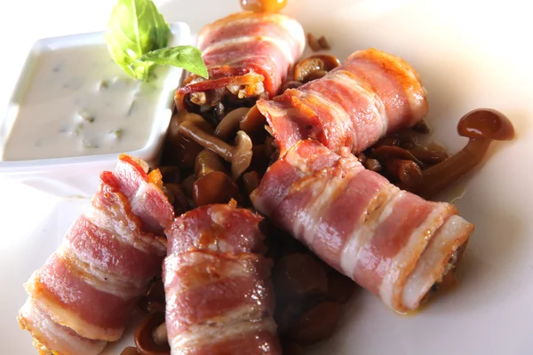 roll with Bacon and mushrooms and sauce on white plate
